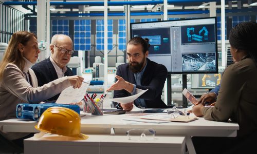 Engineers study detailed schematics of solar panel assembly lines in factory Engineers study detailed schematics of solar panel assembly lines, refining production layouts and component configurations for efficiency, outlining documentation for new prototypes, camera A